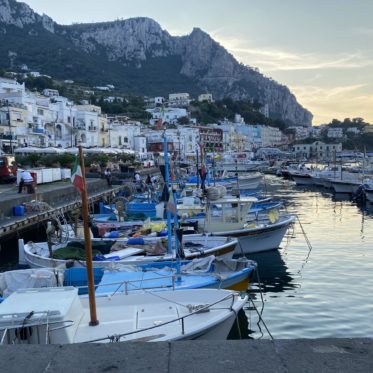 Kleine bootjes in haven van Capri bij zonsondergang