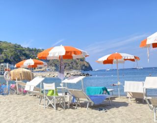 Strand van Ischia met parasols en ligstoelen