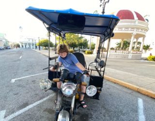 Wolf zit op een taxifiets in Cienfuegos