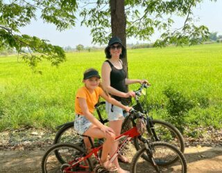 Fietsen met kinderen tussen de rijstvelden in Sukhothai