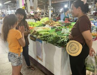 Kind koopt groenten op de markt voor kookworkshop