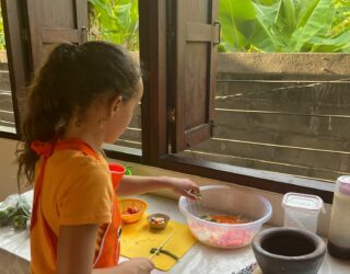 Kind snijdt groentjes bij bananenplantage