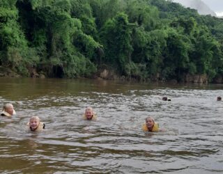 Kinderen zwemmen in de River Kwai