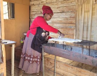 Xhosa vrouw bakt brood in Zuid-Afrika