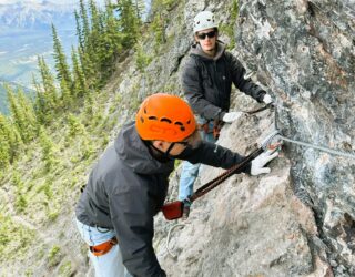 Kids klimmen op de rotsen bij de Via Ferrata in Banff