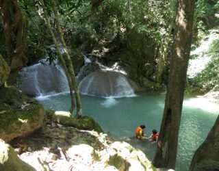 Kinderen zwemmen in de Erawan Falls