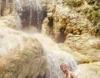 Kind geniet onder de Erawan watervallen