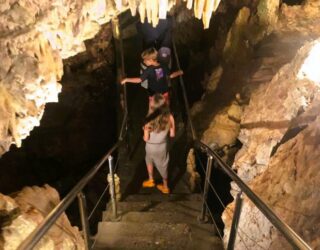 Kinderen wandelen ondergronds in grotten van Diros