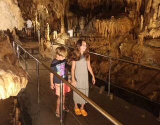 Kinderen wandelen door de betoverende grotten van Diros