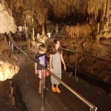 Kinderen wandelen door de betoverende grotten van Diros