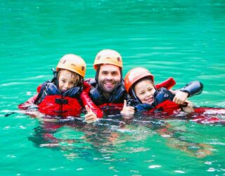 Papa met kinderen op aquatrekking in Slovenië