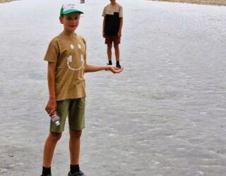 Kinderen op Badwater Basin zoutvlakte in Death Valley