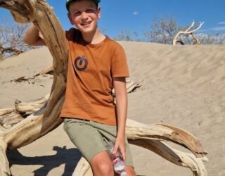 Kind in Mesquite dunes in Death Valley