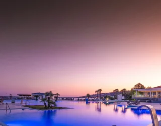 Hotel Alcinj aan het strand met zwembad bij zonsondergang