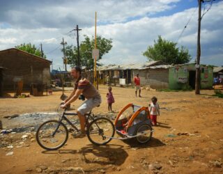 Papa fietst met kinderen door Soweto