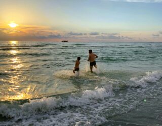 Papa en kind zwemmen in zee in Florida