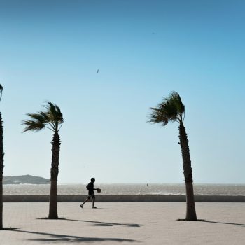 Kind met basketbal tussen palmbomen in Essaouira