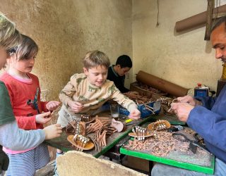 Kinderen helpen bij het maken van sandalen