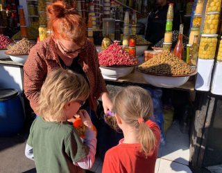 Kinderen proeven van olijven op de markt in de Medina