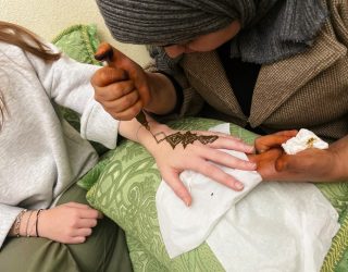 Henna-artieste is een Henna Tattoo aan het tekenen op een hand