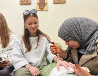 Henna-artieste tekent een Henna tattoo op het hand van een meisje