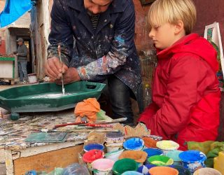 Zouaq artist helpt jongen met zijn kunstwerk