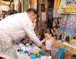 Zouaq artist helpt meisje met haar kunstwerk