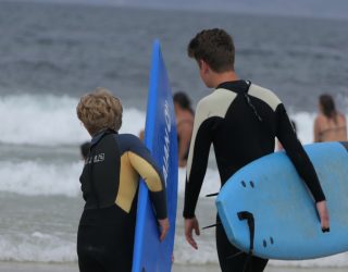 2 jongens op het strand met hun surfplank in Portugal
