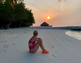 Zitten op witte zand van de Malediven