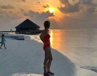 Kiddo medewerker op strand tijdens zonsondergang Malediven