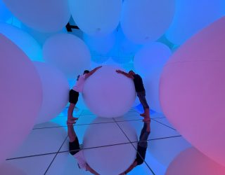 Geert en zijn zoon liggen op bal in teamLab