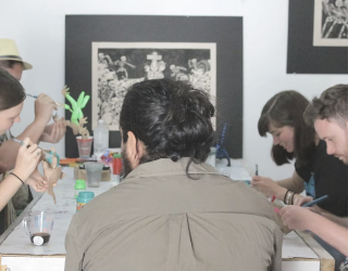 Tafel met mensen die alebrije aan het schilderen zijn