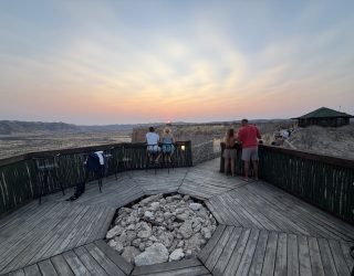 Mensen genieten van zonsondergang vanuit restaurant Ugab