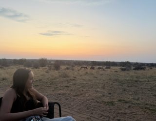 Tiener geniet van zonsondergang in Namibië