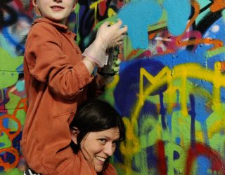 Meisje spuit graffiti op muur in New York