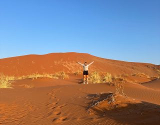 Met handen omhoog in de woestijn Sossuvlei