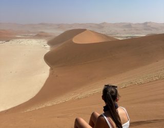 Tiener zit in zand op duin Sossusvlei