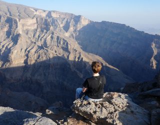 Tiener met uitizcht op Grand Canyon Jebel Shams