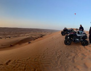 Quadrijden met zonsondergang in de woestijn van Oman