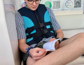 Tiener leest een boek op speedboat in Oman