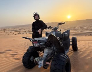 Kind met quad in de woestijn van Oman