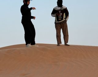 Tiener met gids in de woestijn van Oman