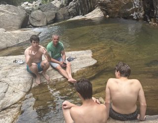 Vader met zijn drie zonen aan natuurlijke waterplek