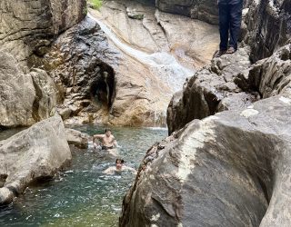 Tiener zwemt in natuurlijke waterplek