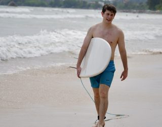 Tiener met surfplank op Weligama Bay